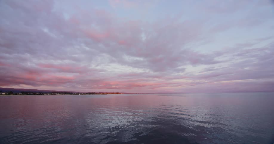 The ocean illuminated by a colorful sky