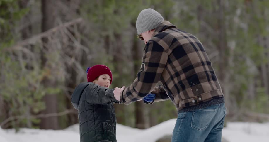 A father helps his son put gloves on