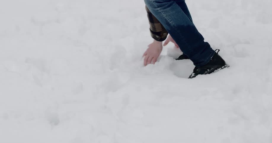 Man playing in the snow and throwing a snowball