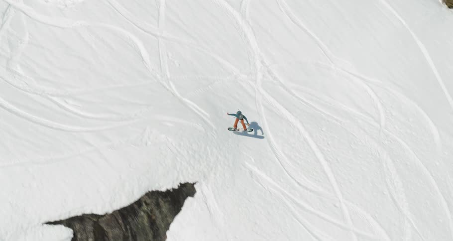 A person snow boards down a hill