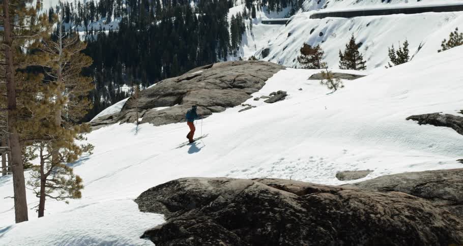Aerial of cross country skier trekking through the snow on mountain ridge