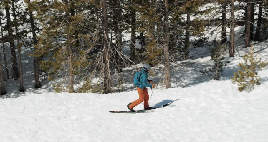 A person uses their ski poles to walk through a flat snow terrain