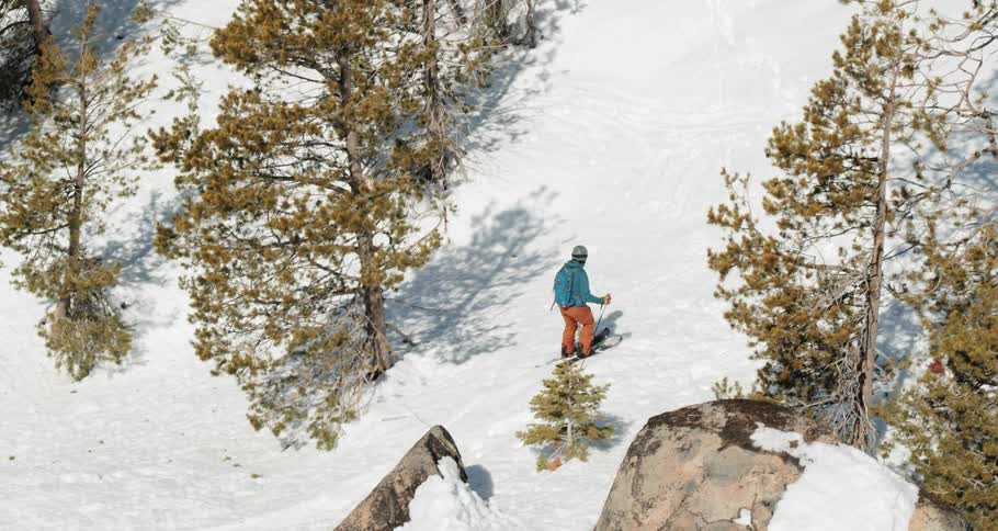 A person skis around a snowy mountain