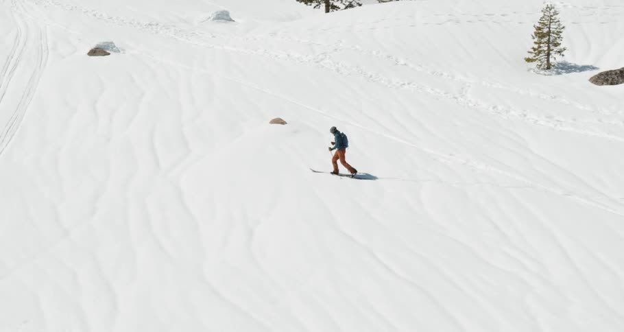 Aerial of lone cross country skier trekking across the snow in the mountains