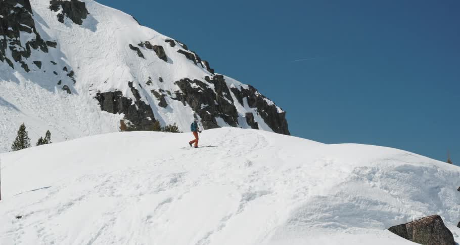 A person with skis walking on a snow covered mountain