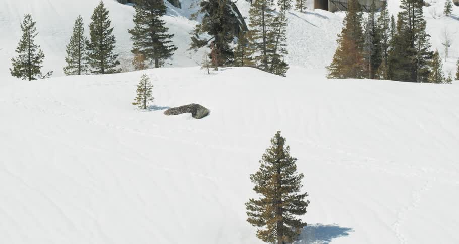 A skier walks across the bottom of a snow covered mountain