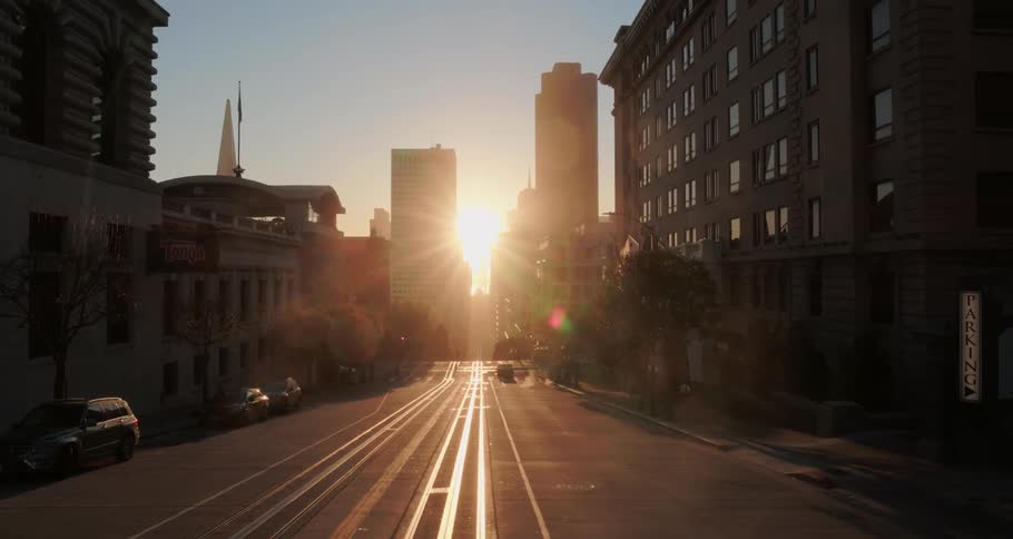 A low sun shining between skyscrapers onto a city street