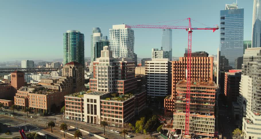A coastal city with buildings roads and a red crane