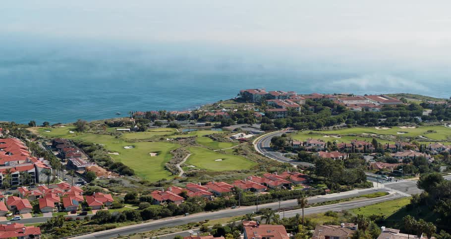 Cars driving past a neighborhood on the coast
