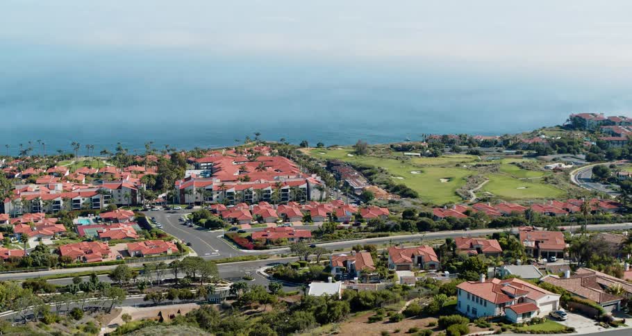 Aerial view of a coastal city with several vehicles driving on the highway