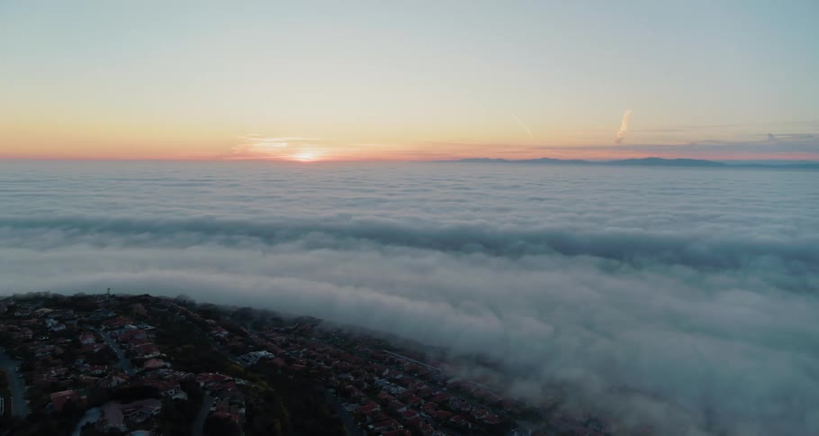 A town near the coast overlooking a foggy ocean