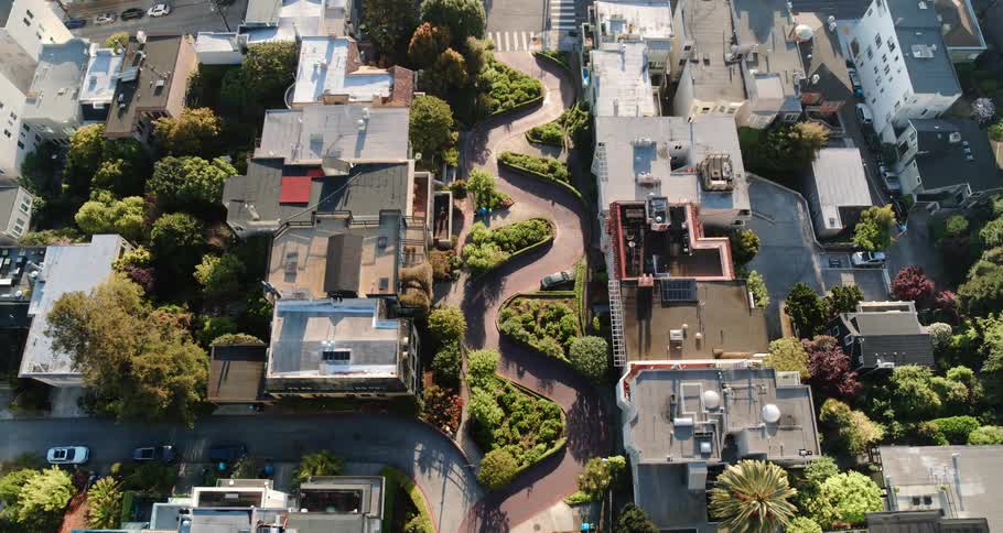 A neighborhood with houses roads and vehicles