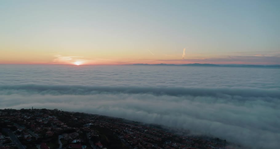 The view above the clouds shows the tip of a town