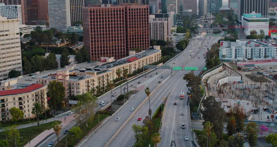 Traffic on highway through city downtown at day
