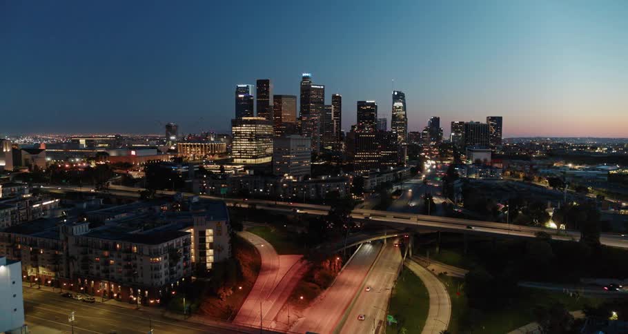 A highway with vehicles and buildings with the city skyline in the background