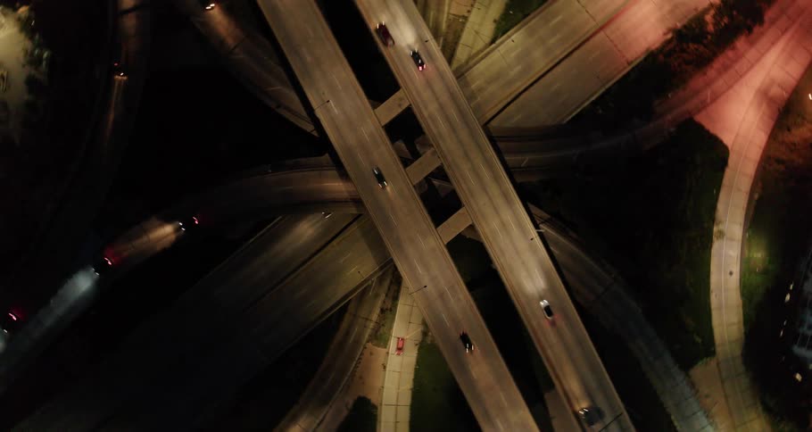 Cars travel on loops of highways at night