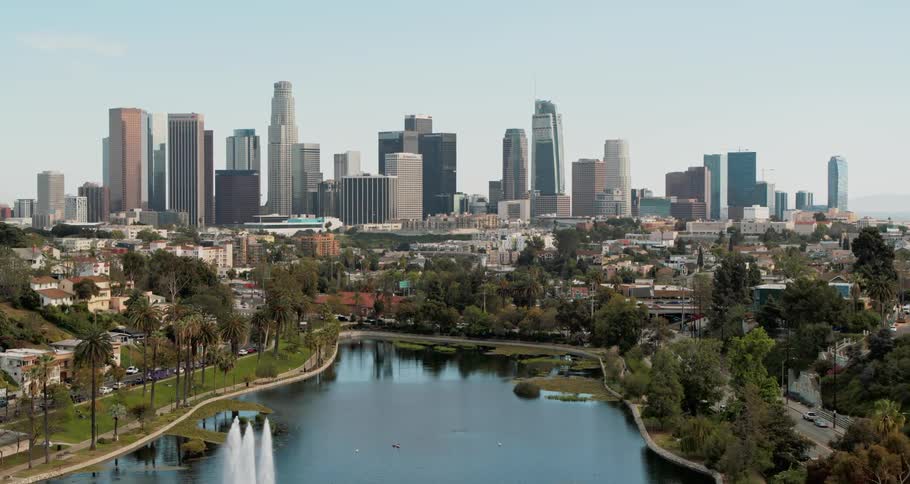 A city skyline with a river and cars driving