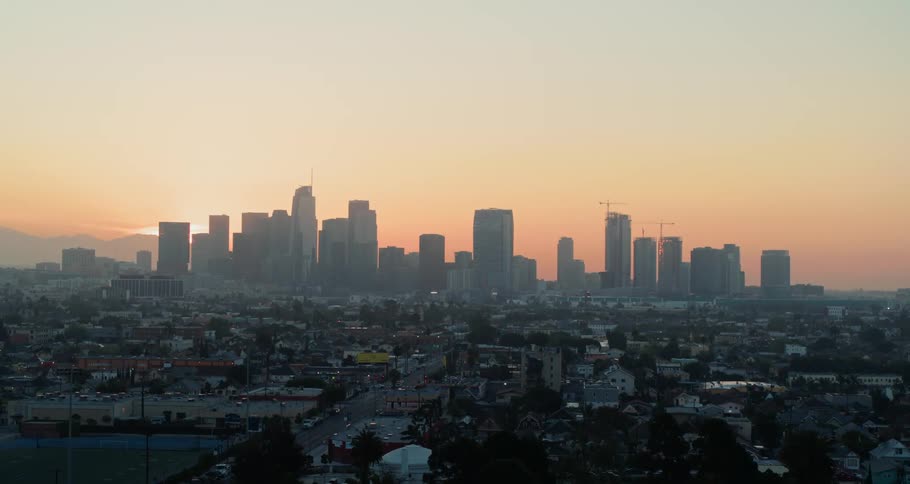 The sun peaking from behind the skyscrapers of a metropolis