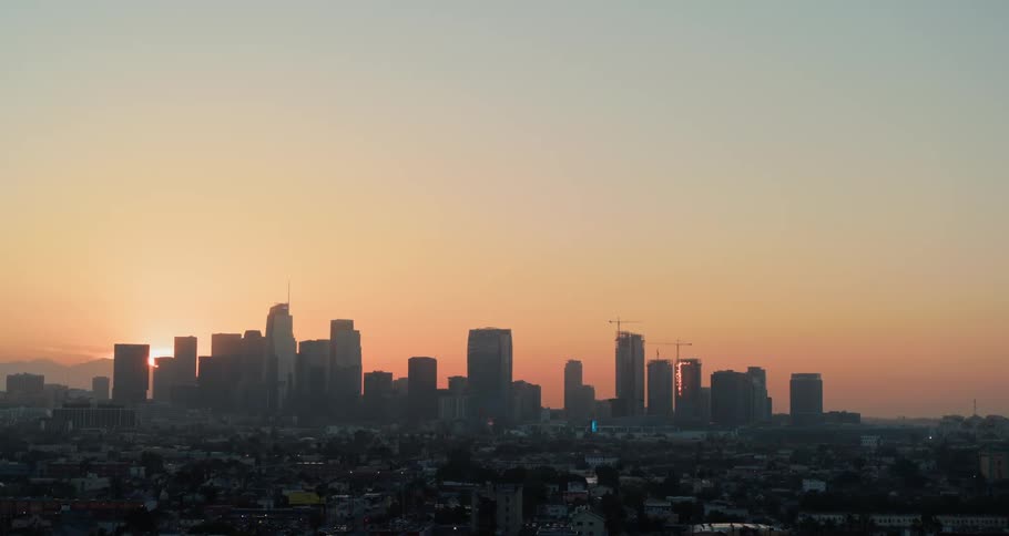 The sky is orange behind the city at dawn