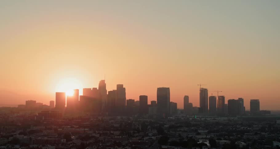 A city skyline with a sunset in the background