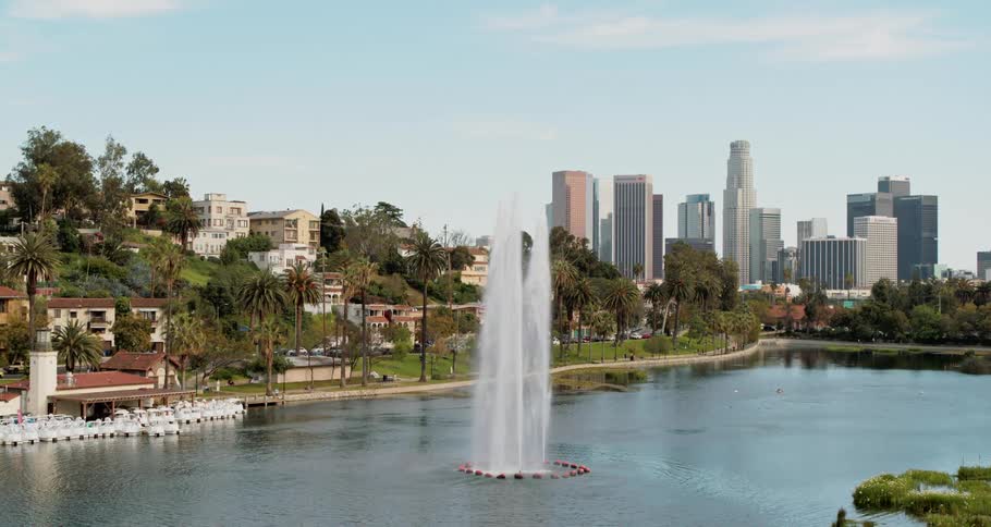 A lake with a fountain sits near a neighborhood near downtown