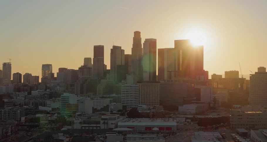 A citys downtown is outlined against the setting sun