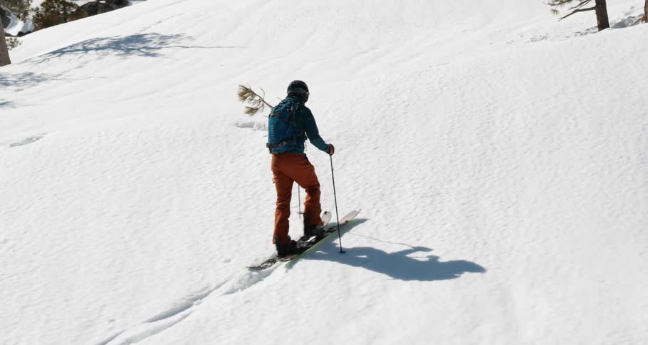 Skier trekking up hill on cross country skis in the mountains