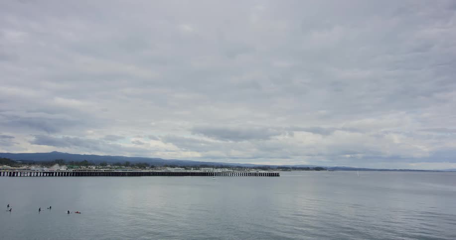 A long pier sits in front of a coastal neighborhood