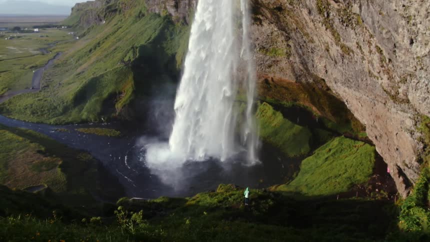 Water from a waterfall pours into the stream below