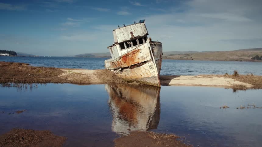 Rusty, abandoned fishing boat grounded on a sandbar
