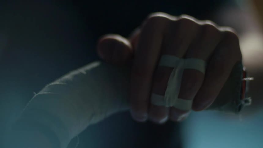 A person is pushing a handle in a dark area