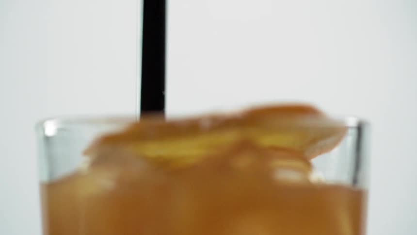 An orange slice is dropped into the drink