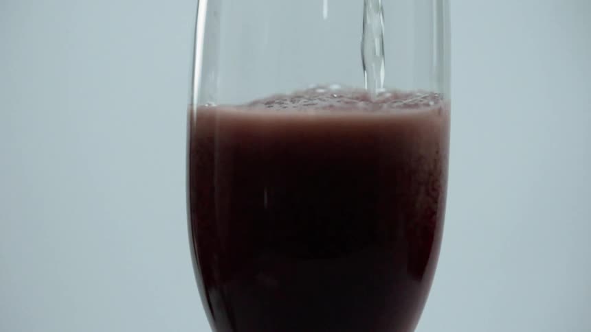 A glass fills with a liquid
