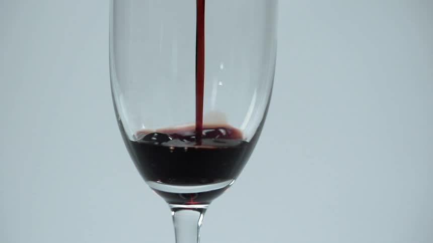 Red wine is being poured into a glass