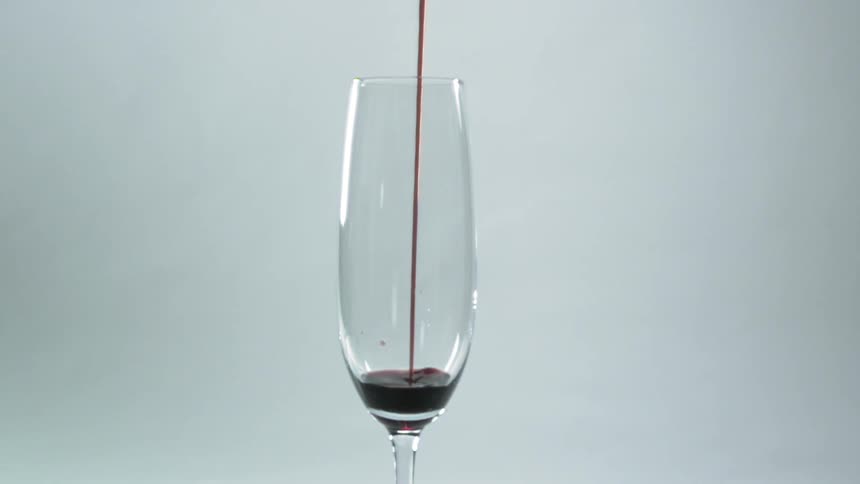 Red liquid pouring into a glass