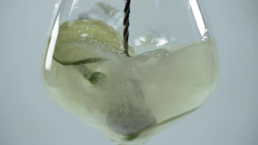 A beverage being stirred with a spoon in a studio