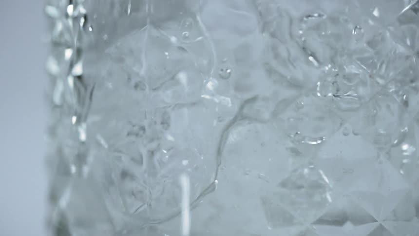Ice cubes falling into a glass of water