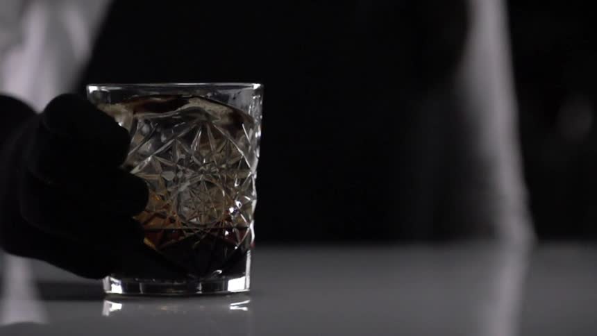 A bartender slides a drink across the top of a bar