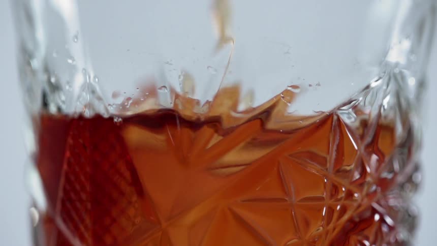 A dark amber liquid pouring into a glass