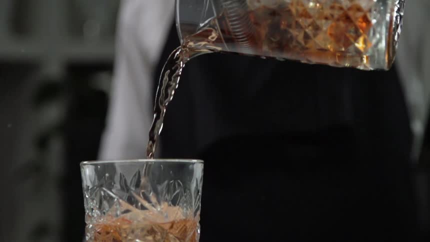 Bartender pours beer into the glass in a bar