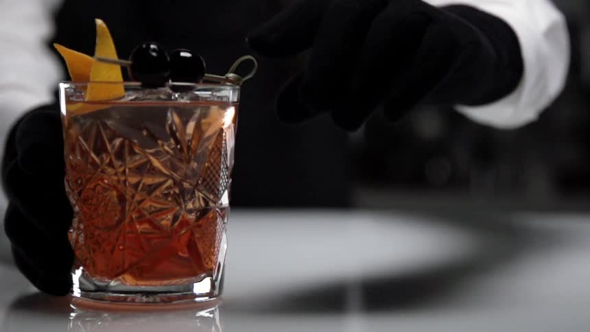 A bartender puts the finishing garnishes on a mixed drink