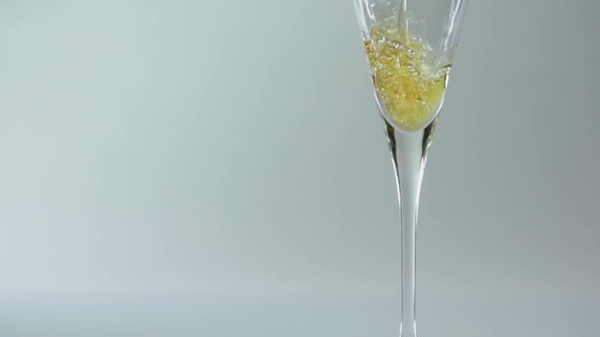 The glass is being filled with champagne