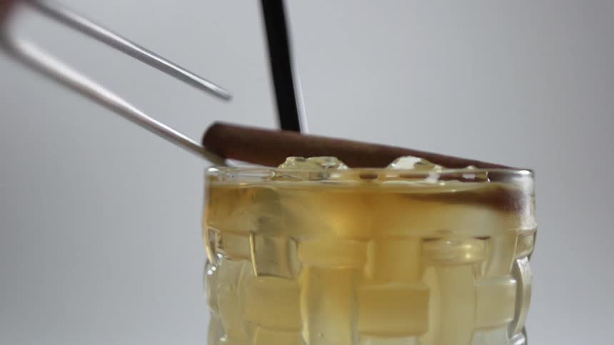 A cinnamon stick is set on top of a cocktail