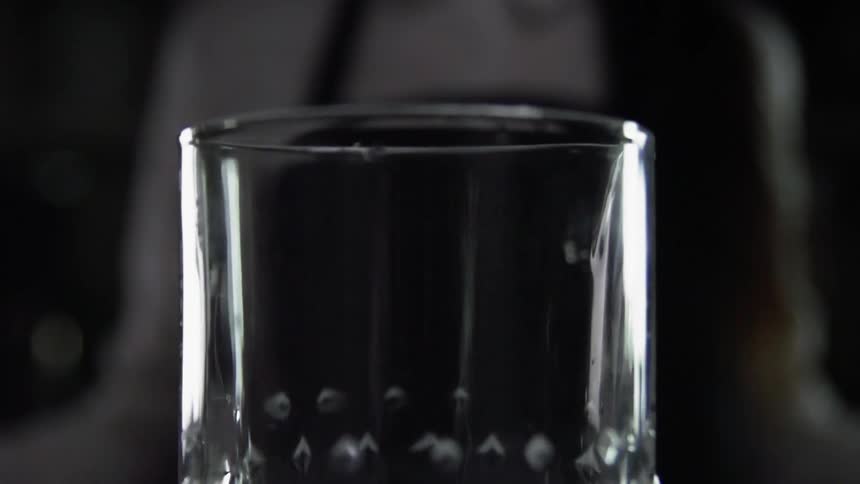 An ice cube falls into a glass pitcher