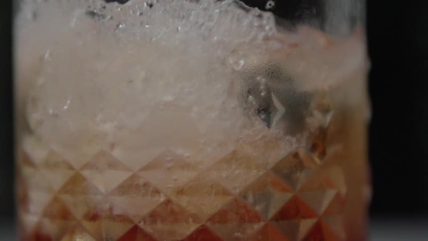 Liquid pours into a glass and foams up