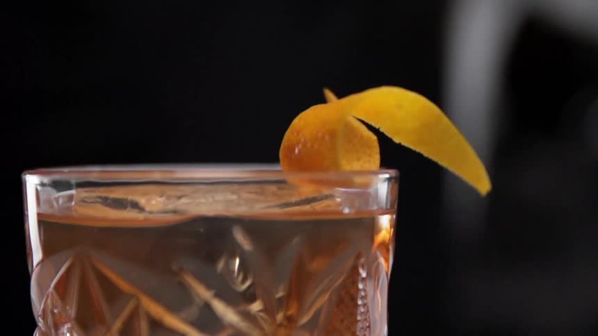 The lemon peel drops onto the drink