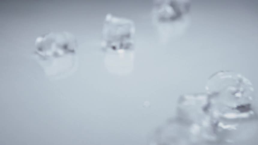Ice cubes sliding across counter in slow motion