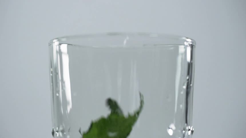 Green leaves falling around the glass