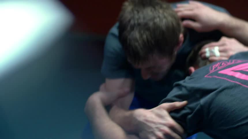 Two people are wrestling in a dark area