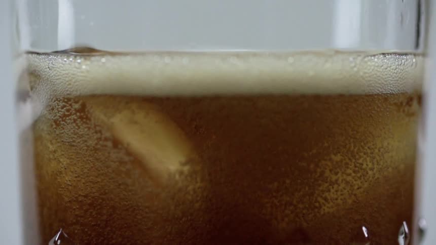 Foam from beer floating to top of glass
